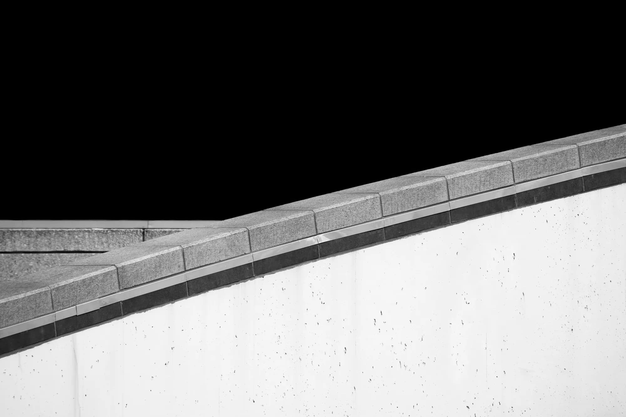 Board-marked concrete wall against a dark sky
